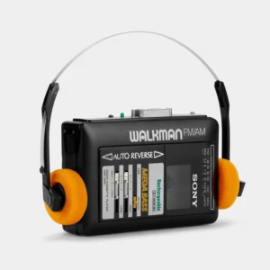 From the Walkman to Wired Headphones in 2026: Why This Audio Design Never Dies 2 Vintage portable cassette player with modern wired headphones and a compact CD player on a warm wooden desk.